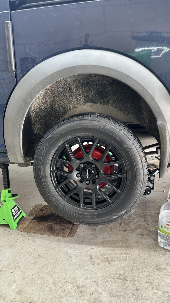 Fleet vehicle with black wheels and refinished red brake drums following brake and suspension maintenance performed by Divine Dents in Aubrey, Texas.